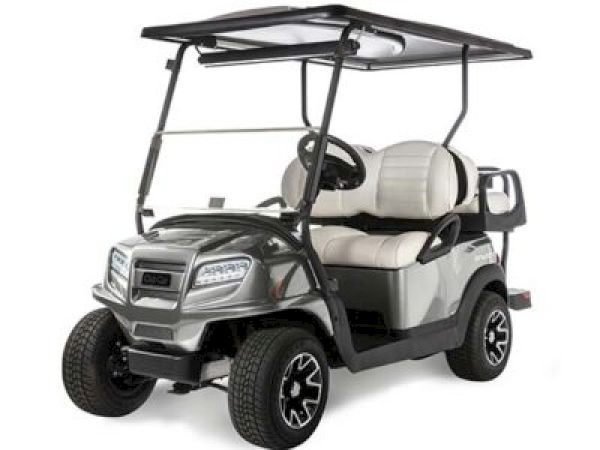 The image shows a silver golf cart with a roof, two beige seats, and black wheels, parked on a white background.